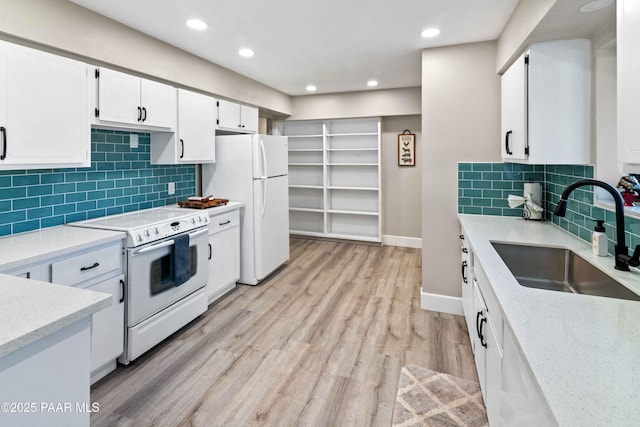 kitchen featuring sink, white cabinetry, light hardwood / wood-style flooring, white appliances, and backsplash