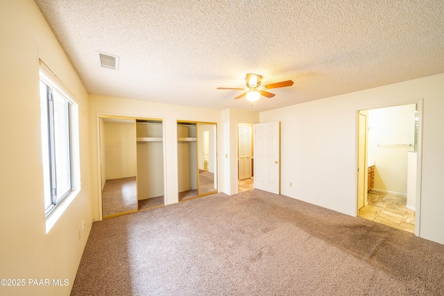 438 Jasmine Ln, Prescott, AZ 86301 - unfurnished bedroom with multiple windows, two closets, light carpet, ensuite bath, and a textured ceiling