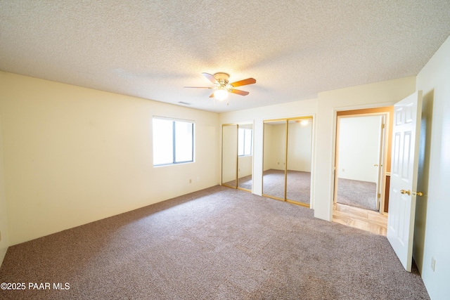 438 Jasmine Ln, Prescott, AZ 86301 - unfurnished bedroom featuring carpet, multiple closets, a ceiling fan, and a textured ceiling