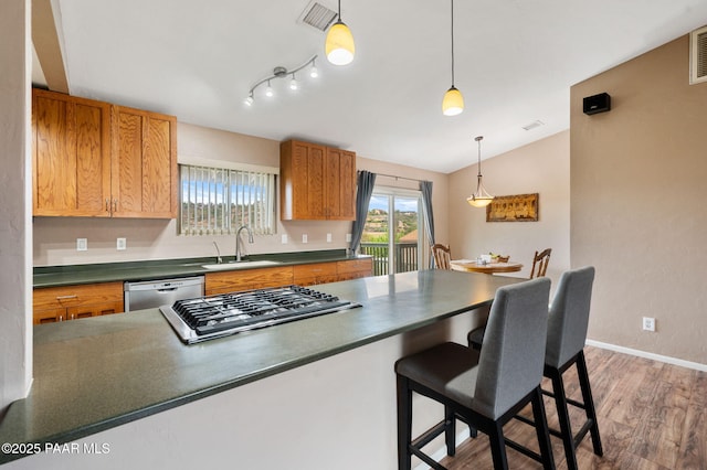 2770 Ridge Rd, Prescott, AZ 86301 - kitchen featuring dark countertops, light wood finished floors, appliances with stainless steel finishes, a breakfast bar, and hanging light fixtures