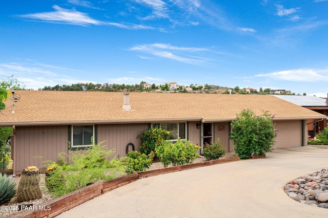 2770 Ridge Rd, Prescott, AZ 86301 - ranch-style home featuring a garage, concrete driveway, a chimney, a shingled roof, and board and batten siding