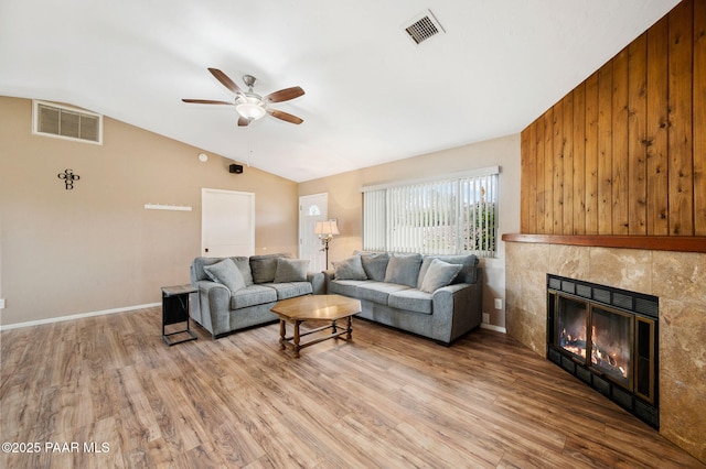 2770 Ridge Rd, Prescott, AZ 86301 - living area with vaulted ceiling, ceiling fan, wood finished floors, a tiled fireplace, and wood walls