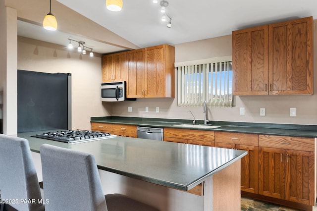 2770 Ridge Rd, Prescott, AZ 86301 - kitchen with appliances with stainless steel finishes, rail lighting, dark countertops, a kitchen bar, and brown cabinetry