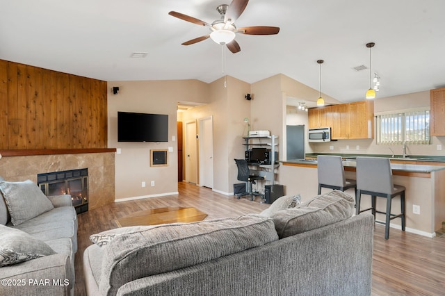 2770 Ridge Rd, Prescott, AZ 86301 - living area with light wood-type flooring, ceiling fan, lofted ceiling, and a tiled fireplace