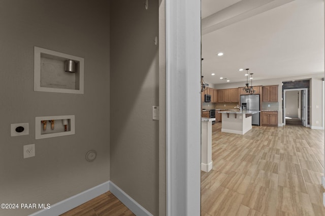 laundry room featuring washer hookup, light hardwood / wood-style floors, and electric dryer hookup