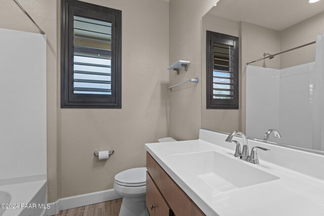 bathroom with hardwood / wood-style floors, vanity, and toilet