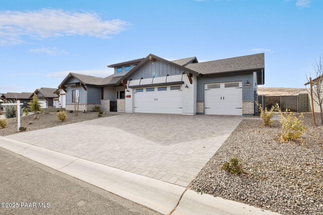 4655 E Alma Ln, Prescott Valley, AZ 86314 - view of front of home with a garage, board and batten siding, driveway, brick siding, and a shingled roof