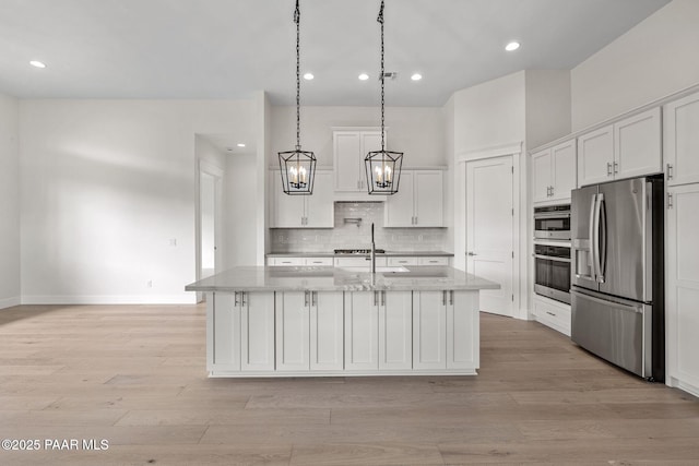 4655 E Alma Ln, Prescott Valley, AZ 86314 - kitchen featuring stainless steel appliances, white cabinets, tasteful backsplash, a chandelier, and light wood-style flooring