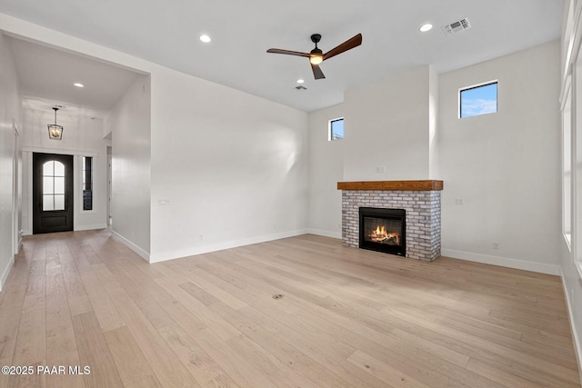 4655 E Alma Ln, Prescott Valley, AZ 86314 - unfurnished living room with healthy amount of natural light, light wood finished floors, a ceiling fan, a fireplace, and recessed lighting