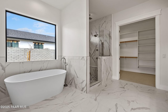 4655 E Alma Ln, Prescott Valley, AZ 86314 - full bath featuring marble look tiles, a marble finish shower, a soaking tub, a walk in closet, and tile walls