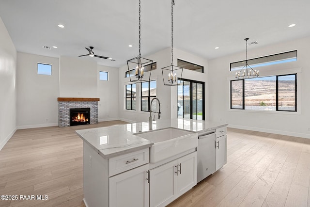 4655 E Alma Ln, Prescott Valley, AZ 86314 - kitchen with a chandelier, light wood finished floors, a brick fireplace, open floor plan, and hanging light fixtures