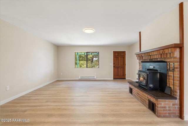 7521 Paseo Hermoso, Prescott Valley, AZ 86314 - unfurnished living room with a baseboard heating unit, a wood stove, light wood finished floors, and baseboards