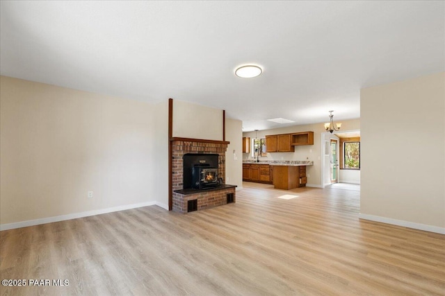 7521 Paseo Hermoso, Prescott Valley, AZ 86314 - unfurnished living room with light wood finished floors, a chandelier, and baseboards