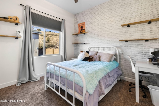 carpeted bedroom featuring brick wall and baseboards