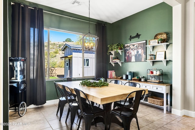 dining space with light tile patterned flooring, baseboards, and a chandelier