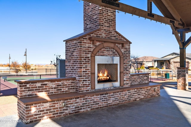 exterior space featuring fence and an outdoor brick fireplace