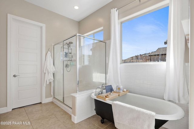 bathroom with a tub, tile patterned flooring, and a stall shower