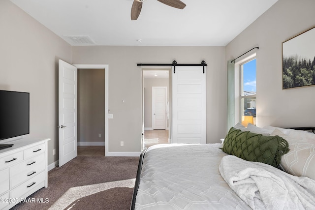 bedroom featuring a ceiling fan, visible vents, a barn door, baseboards, and carpet