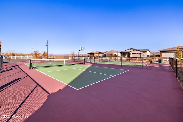 view of tennis court featuring fence