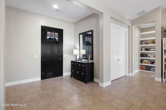 entryway with baseboards, visible vents, and light tile patterned floors