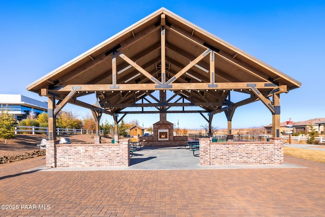 view of property's community featuring fence, a gazebo, and a patio area