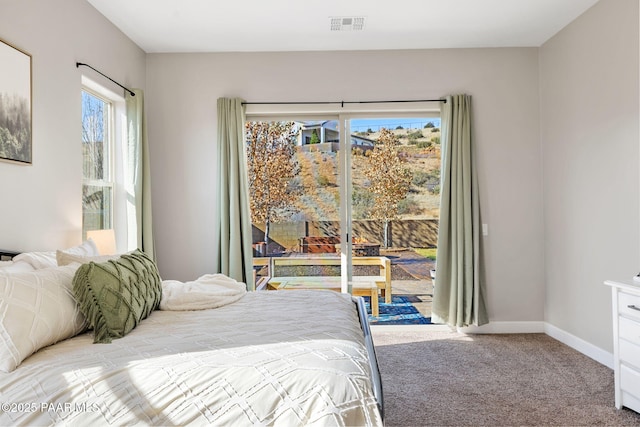 carpeted bedroom with visible vents, baseboards, and access to outside