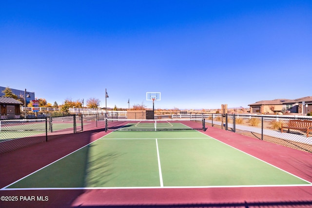 view of tennis court with fence and community basketball court