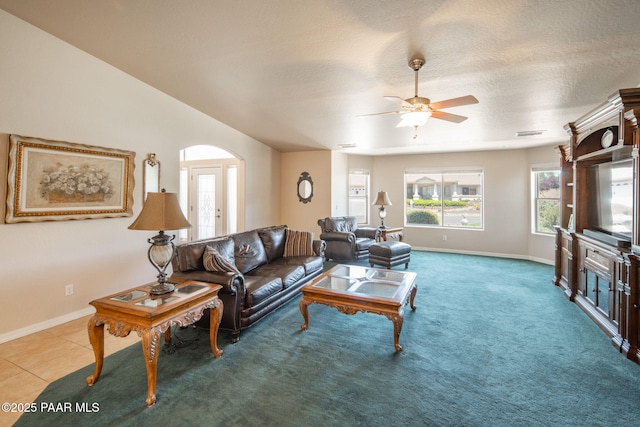 carpeted living area featuring tile patterned floors, visible vents, a textured ceiling, and ceiling fan