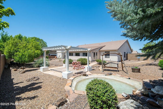 back of property featuring stucco siding, a pergola, a jacuzzi, a fenced backyard, and a patio area