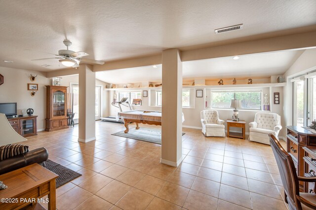 living area with visible vents, a textured ceiling, pool table, light tile patterned floors, and vaulted ceiling