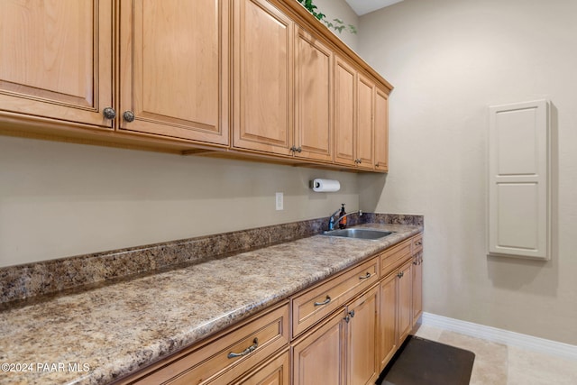 kitchen featuring light stone countertops, sink, and light tile patterned floors