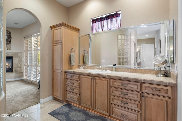 bathroom featuring tile patterned floors, a fireplace, and vanity