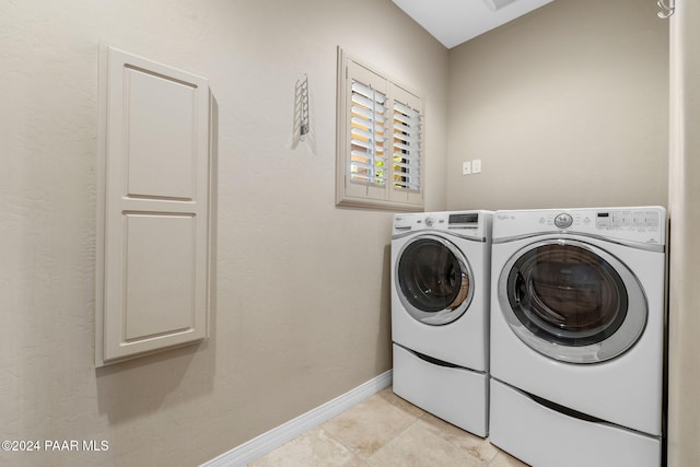 laundry area featuring light tile patterned flooring, cabinets, and separate washer and dryer