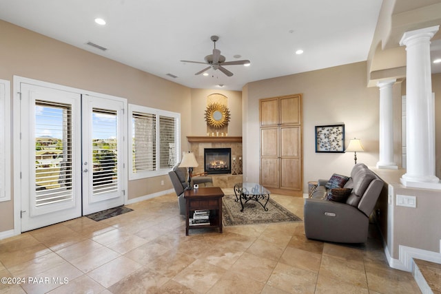 living room featuring a tile fireplace, french doors, light tile patterned floors, and ceiling fan