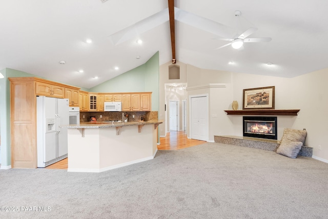 kitchen featuring a kitchen bar, vaulted ceiling with beams, tasteful backsplash, light stone counters, and white appliances