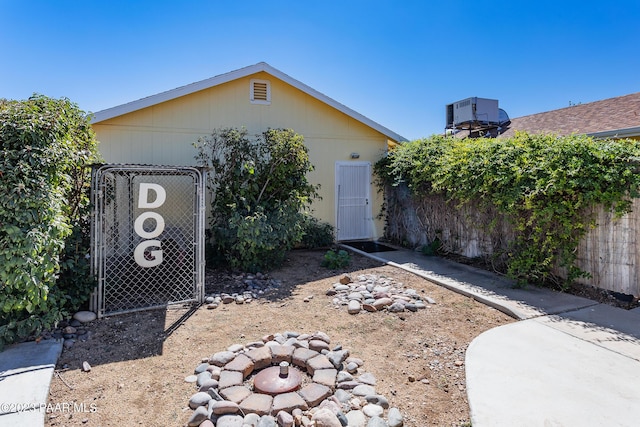 view of front facade featuring a fire pit and central AC unit