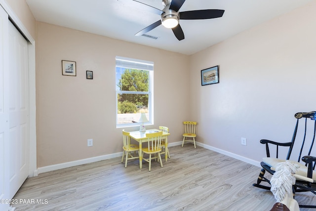 sitting room with ceiling fan and light wood-type flooring