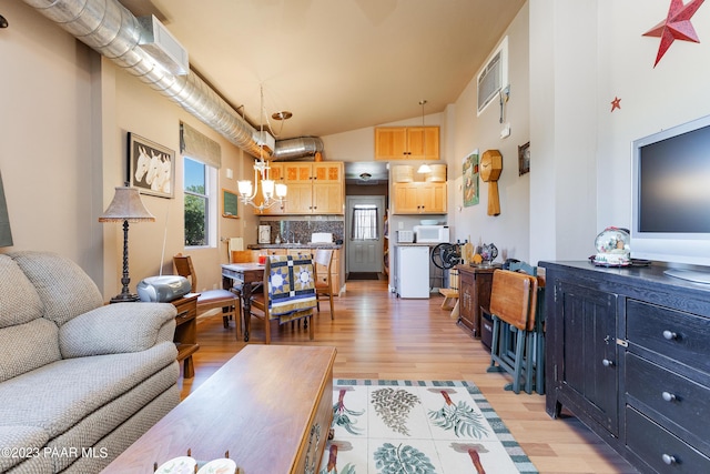 living room featuring a chandelier, light hardwood / wood-style flooring, and vaulted ceiling