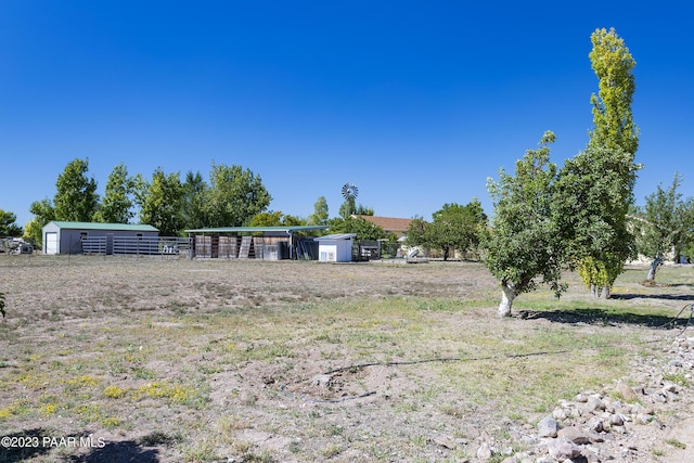 view of yard with a rural view and an outdoor structure