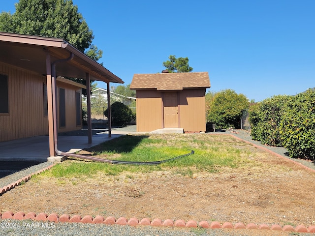 view of yard featuring a patio and a storage unit