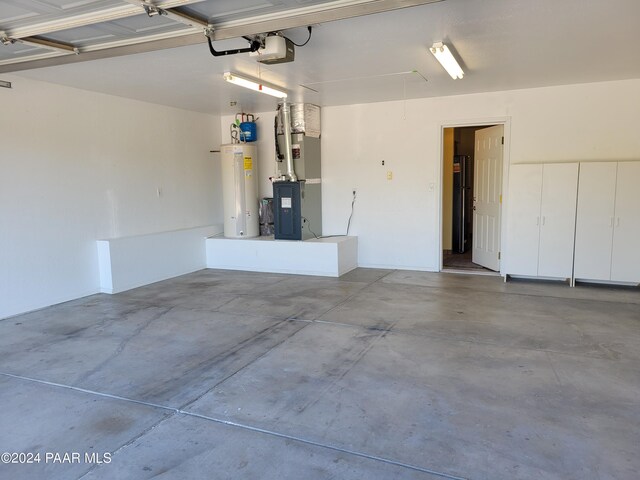 garage with heating unit, a garage door opener, and water heater