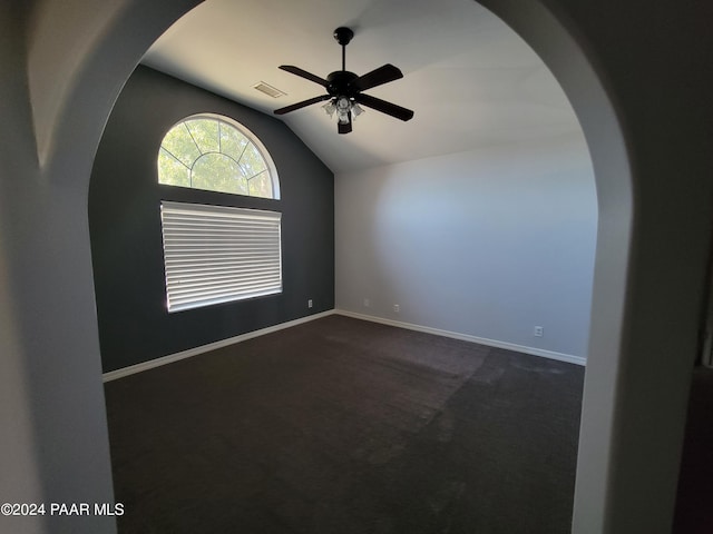 carpeted empty room featuring vaulted ceiling and ceiling fan