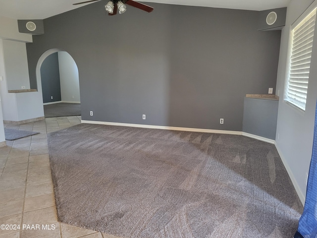 tiled spare room with vaulted ceiling and ceiling fan