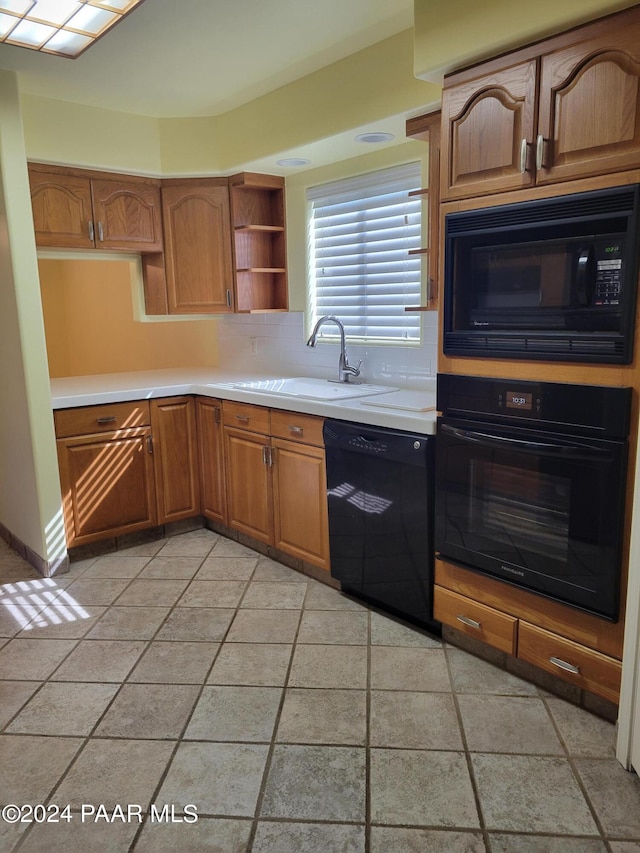 kitchen with decorative backsplash, sink, and black appliances