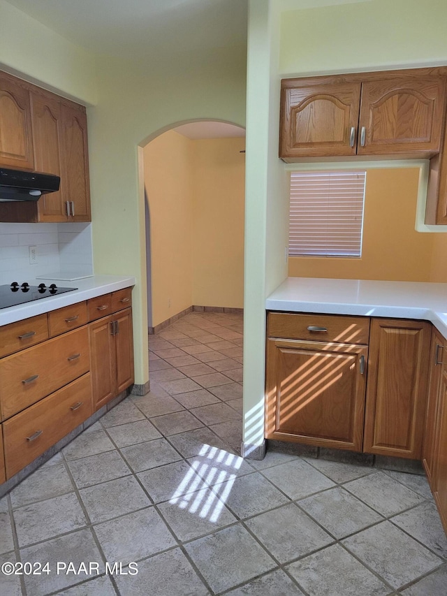 kitchen featuring ventilation hood, decorative backsplash, and black electric cooktop