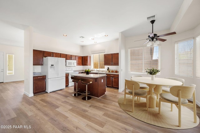 3824 N Wakefield Dr, Prescott Valley, AZ 86314 - kitchen featuring white appliances, a kitchen breakfast bar, wood finished floors, a center island, and recessed lighting