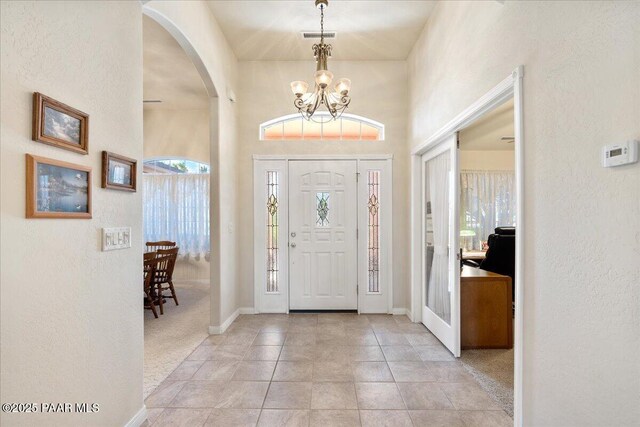 977 Kristin St, Chino Valley, AZ 86323 - foyer featuring arched walkways, a chandelier, a textured wall, and tile patterned flooring