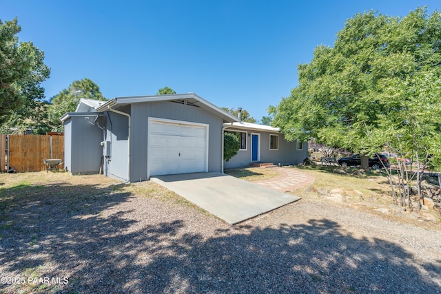 single story home with driveway, a garage, and fence