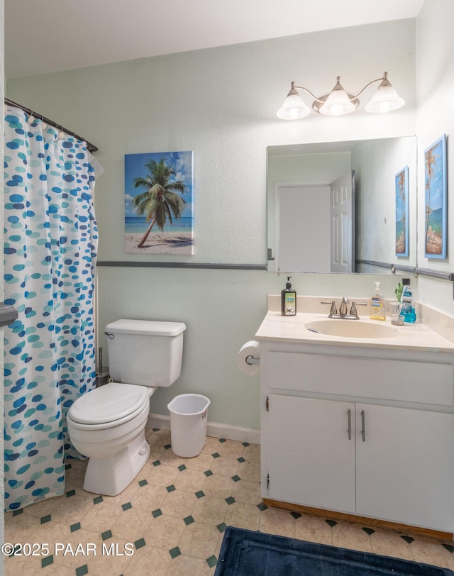 full bathroom featuring vanity, curtained shower, toilet, and baseboards