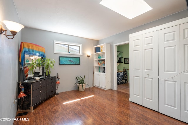 interior space featuring a skylight, a closet, and wood finished floors